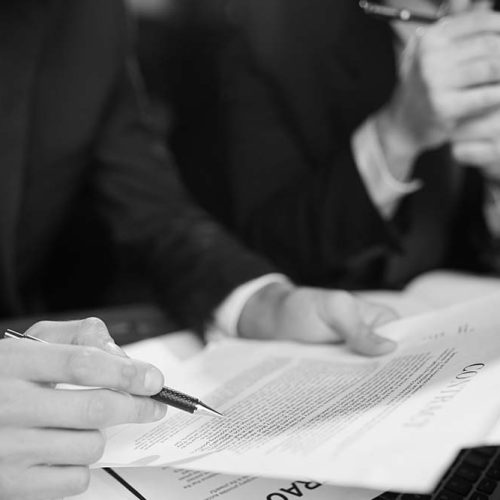 Closeup shot of unrecognizable businessman reading contract documentation at meeting with financial partner